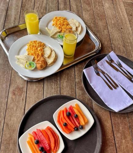 three plates of food on a tray with orange juice at Eco Hotel Nigüíto in Medellín