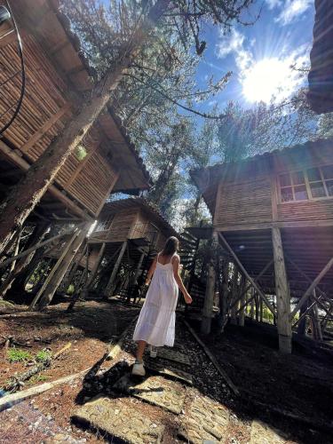 a woman in a white dress standing in front of a building at Eco Hotel Nigüíto in Medellín