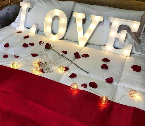 a bed with a love sign and roses on it at Eco Hotel Nigüíto in Medellín
