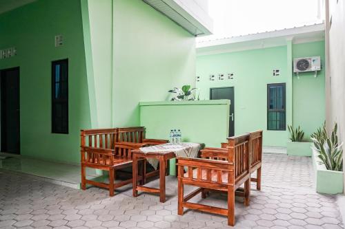 班达楠榜OYO 93695 Guest House Riharti Syariah的建筑物内配有桌椅的露台