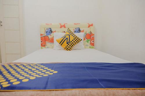 a bed with a blue blanket and pillows on it at OYO 2417 Melati Residence in Blitar