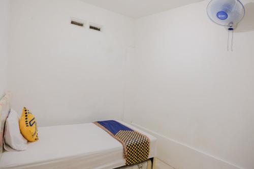 a white room with a bench and a chair at OYO 2417 Melati Residence in Blitar