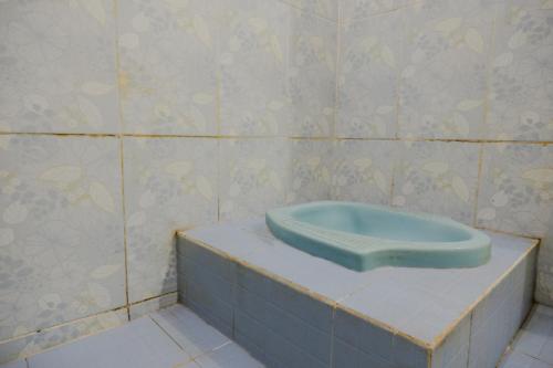 a bathroom with a blue urinal on a counter at OYO 2417 Melati Residence in Blitar
