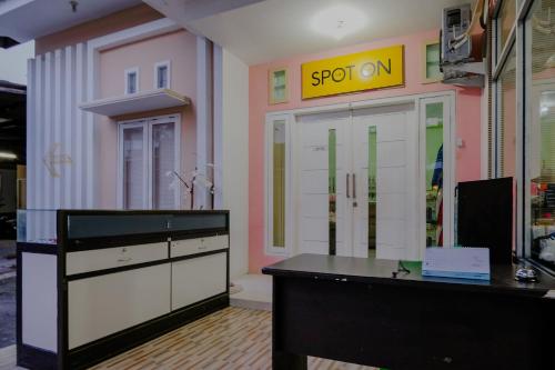 an office with a desk and a sign on the wall at OYO 2417 Melati Residence in Blitar