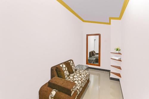 a living room with a chair and a mirror at Hotel O Homestay Antara in Gilimanuk