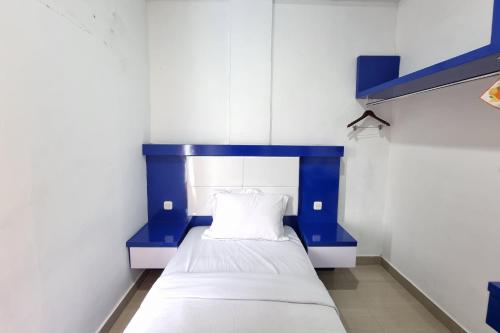 a blue and white bed in a room at Hotel O Anara Residence & Guest House in Medan