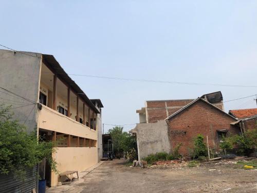 an empty street in an old building next to a brick building at Hotel O Homestay Puri Indah SyariahNearBandara Internasional Juanda in Betro