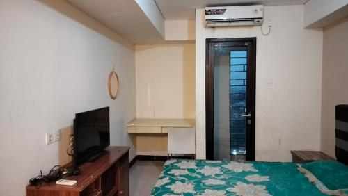 Телевизор и/или развлекательный центр в OYO 94087 Apartemen 19 Avenue By Rh