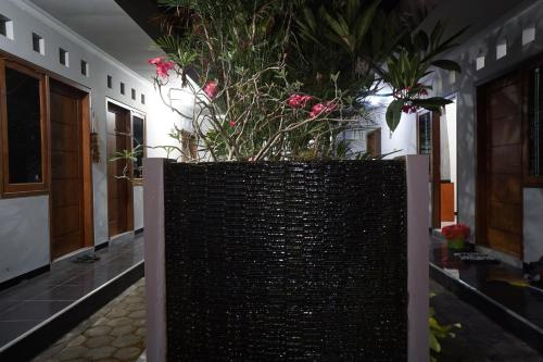 a large planter with pink flowers in a building at OYO Life 93045 Kost Putra Bu Ketut in Lumajang