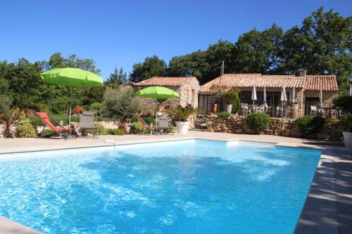 a swimming pool in front of a house at Le Hameau Fleur de Pierres , Chambre , Gite et Table d'Hôtes in Murs
