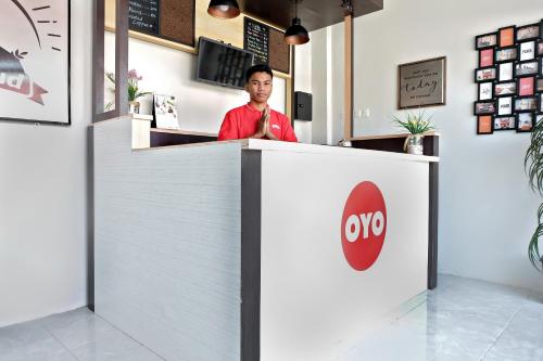 a man sitting at a counter in a restaurant at Super OYO 2756 Anata in Makassar