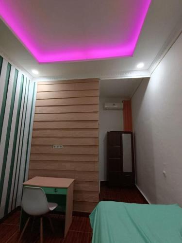 a room with a table and a purple ceiling at OYO Life 93158 Kost Asaka in Serang
