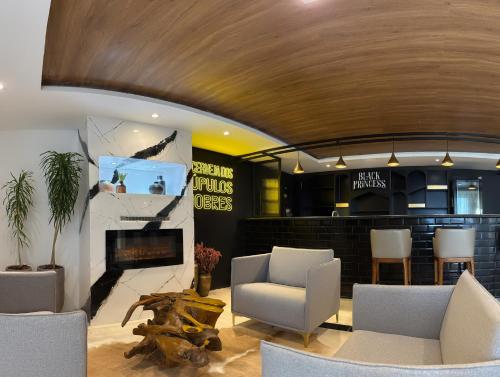 a living room with chairs and a fireplace at Gran Paradiso Campos do Jordão By Ventura OFICIAL in Campos do Jordão