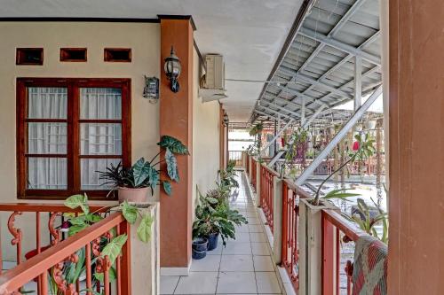einen Balkon eines Gebäudes mit Topfpflanzen in der Unterkunft OYO Life 91480 Putridapisa Syariah in Sumedang