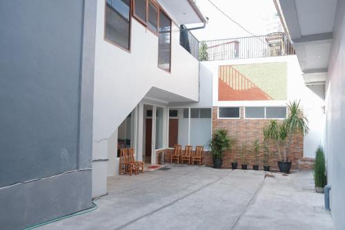 a white building with chairs and tables in a courtyard at Hotel O 111 Residence in Batu