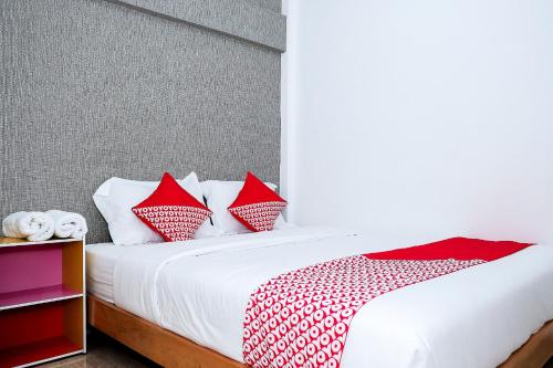 a bedroom with a bed with red and white pillows at Hotel O 111 Residence in Batu