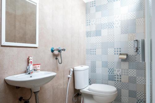 a bathroom with a toilet and a sink at Hotel O 111 Residence in Batu