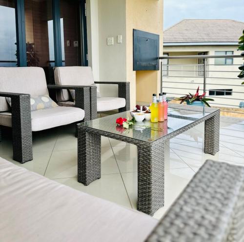 a patio with a table and chairs with drinks on it at The Ridge At Mountain View Vacation Home in Boschrand