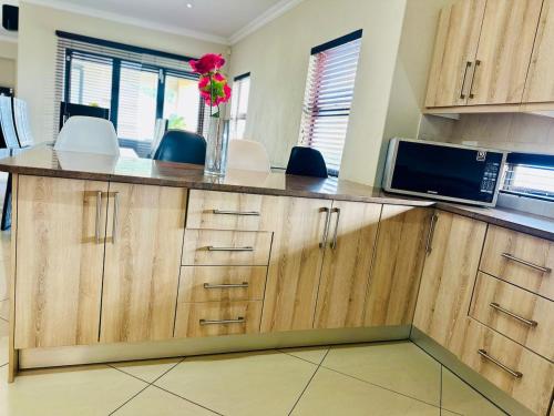 a kitchen with a counter with a vase of flowers on it at The Ridge At Mountain View Vacation Home in Boschrand