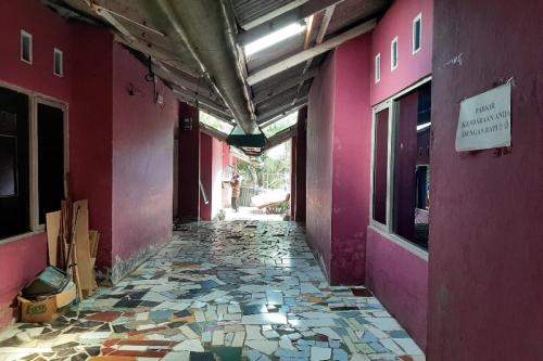 an empty hallway of a building with pink walls at OYO 90555 Vina Pavilion in Bengkulu