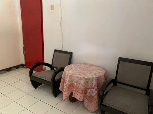 a room with a table and two chairs and a red door at OYO Life 93841 Panorama Dewi in Subang