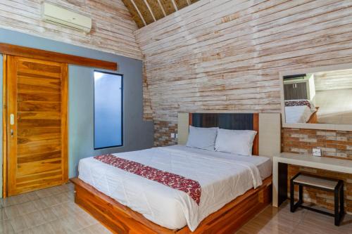 a bedroom with a large bed and a desk at Belvilla Moksha Haven Pandawa BaliNearNirwana Garden Bali in Jembrana