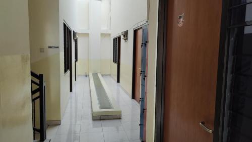an empty hallway with a row of doors in a building at Hotel O C16 Siwalankerto Syariah in Surabaya