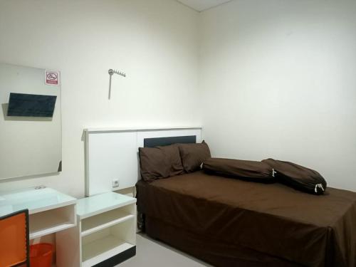 a bedroom with a bed and a mirror at Hotel O Lourdes Blessing Hill in Tomohon