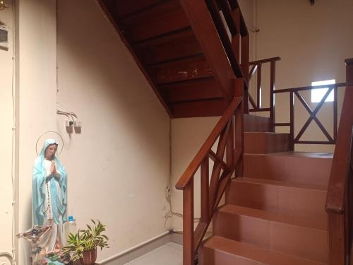 a statue of a nun standing next to a staircase at Hotel O Lourdes Blessing Hill in Tomohon