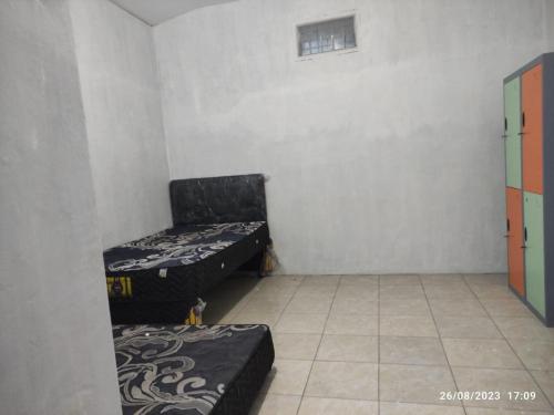 a small room with two beds in the corner at Hotel O Lina Homestay Syariah in Sedati
