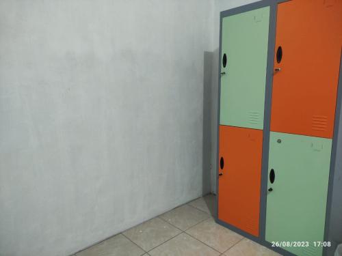 a corridor with orange and white lockers in a room at Hotel O Lina Homestay Syariah in Sedati