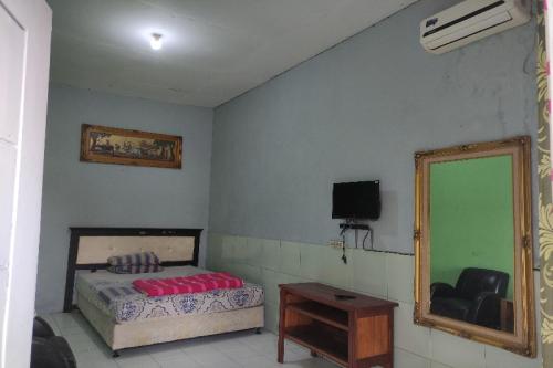 a bedroom with a bed and a mirror at SPOT ON 91105 Hotel Salsabila in Magelang