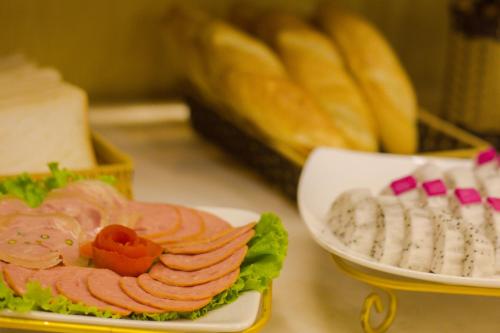 a plate of food with a sandwich and other foods at Golden Art Hotel in Hanoi