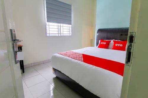 Un dormitorio con una cama con almohadas rojas. en Hotel O Nami House, en Medan