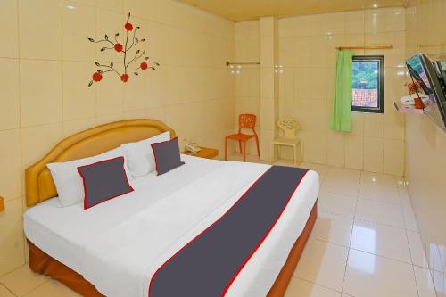 a bedroom with a large bed in a room at Hotel O Sion Holiday in South Tangerang