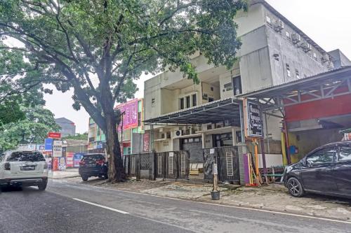 a street with cars parked in front of a building at Hotel O Lily House in Tangerang