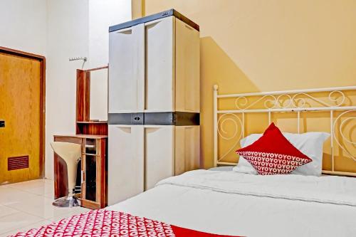 a bedroom with a large bed with a red pillow at Hotel O Lily House in Tangerang