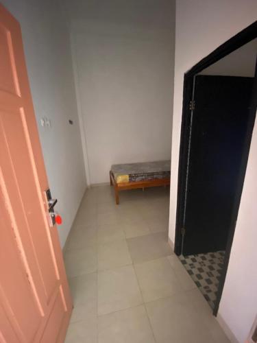 a hallway with a door and a bench in a room at Hotel O Almeerah Homestay Syariah Near RS Hermina in Pampang
