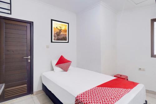 a bedroom with a bed with a red and white blanket at Townhouse Oak Ancol in Jakarta