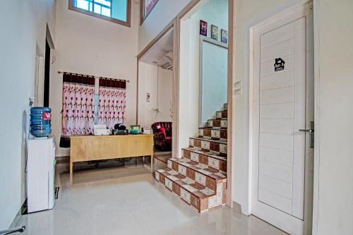a hallway with a door and stairs in a house at Hotel O Timur Raya Homestay Syariah in Pekanbaru