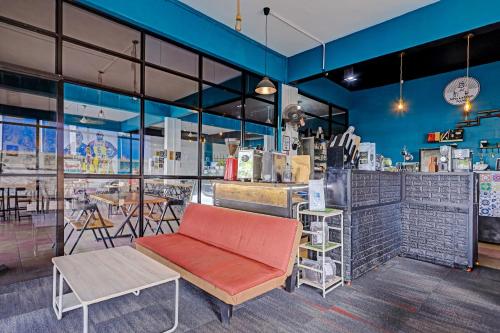 a room with a bench and a bar with tables at Collection O 91499 John Lebron House in Sagulung
