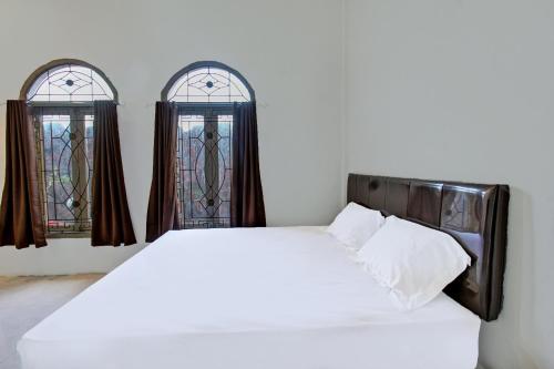 Postel nebo postele na pokoji v ubytování Hotel O Ayu Bypass MansionNearBundaran Gerung