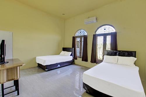 Postel nebo postele na pokoji v ubytování Hotel O Ayu Bypass MansionNearBundaran Gerung