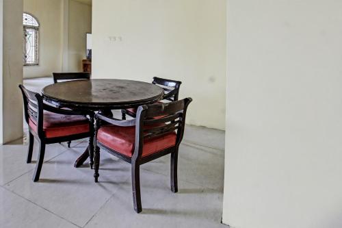 a dining room table with chairs and a table and a table and chairs at Hotel O Ayu Bypass MansionNearBundaran Gerung in Kuripan