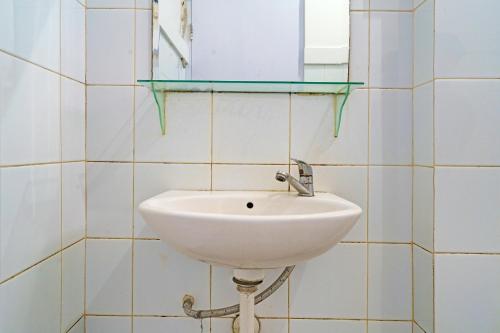 a white sink in a tiled bathroom with a mirror at Collection O 92277 Setra Priangan Guest House in Bandung