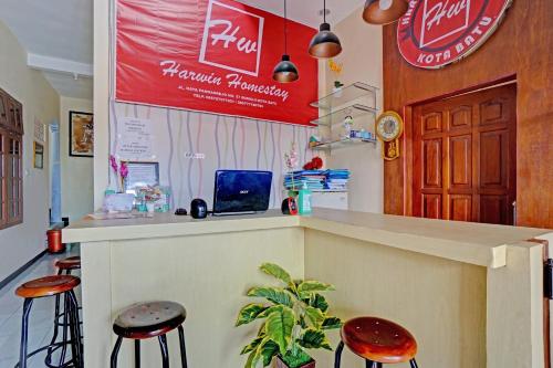 a bar in a restaurant with two stools at Hotel O Harwin Homestay in Batu