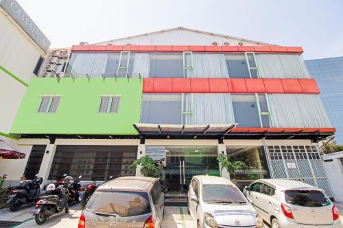a building with cars parked in front of it at Collection O near Paris Van Java formerly Cassa Dua Hotel in Bandung