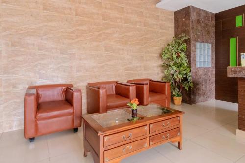 una sala d'attesa con sedie in pelle e tavolo di Hotel O Medan near Balai Kota Lama formerly Hotel Labuhan Raya a Medan