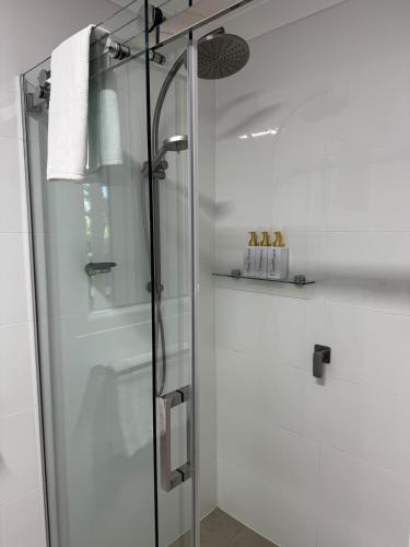 a shower with a glass door in a bathroom at Frogs by the Sea in Cronulla