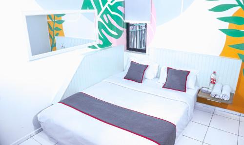 a white bed with two pillows in a room at Collection O Tunas Plaza Residence in Bekasi